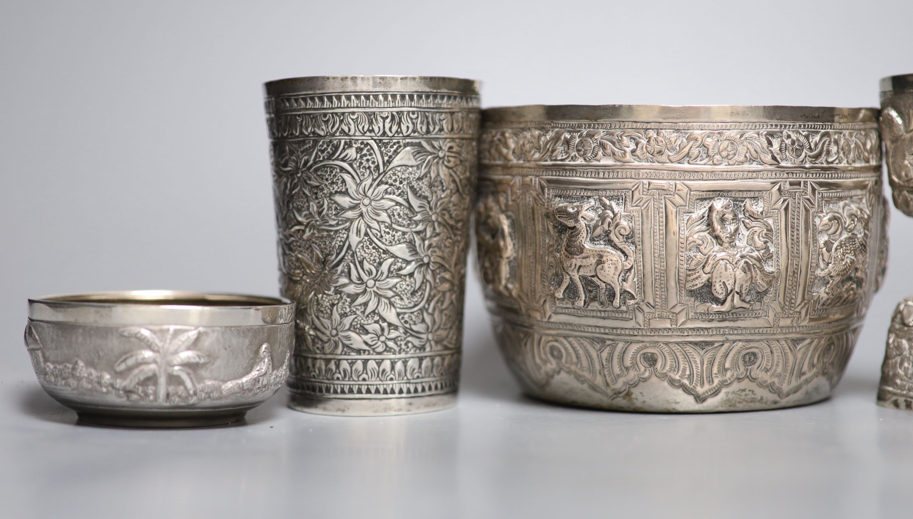 A group of Indian items including a white metal bowl embossed with animals, diameter 14.2cm, cream jug, measure, bowl, dish and beaker.